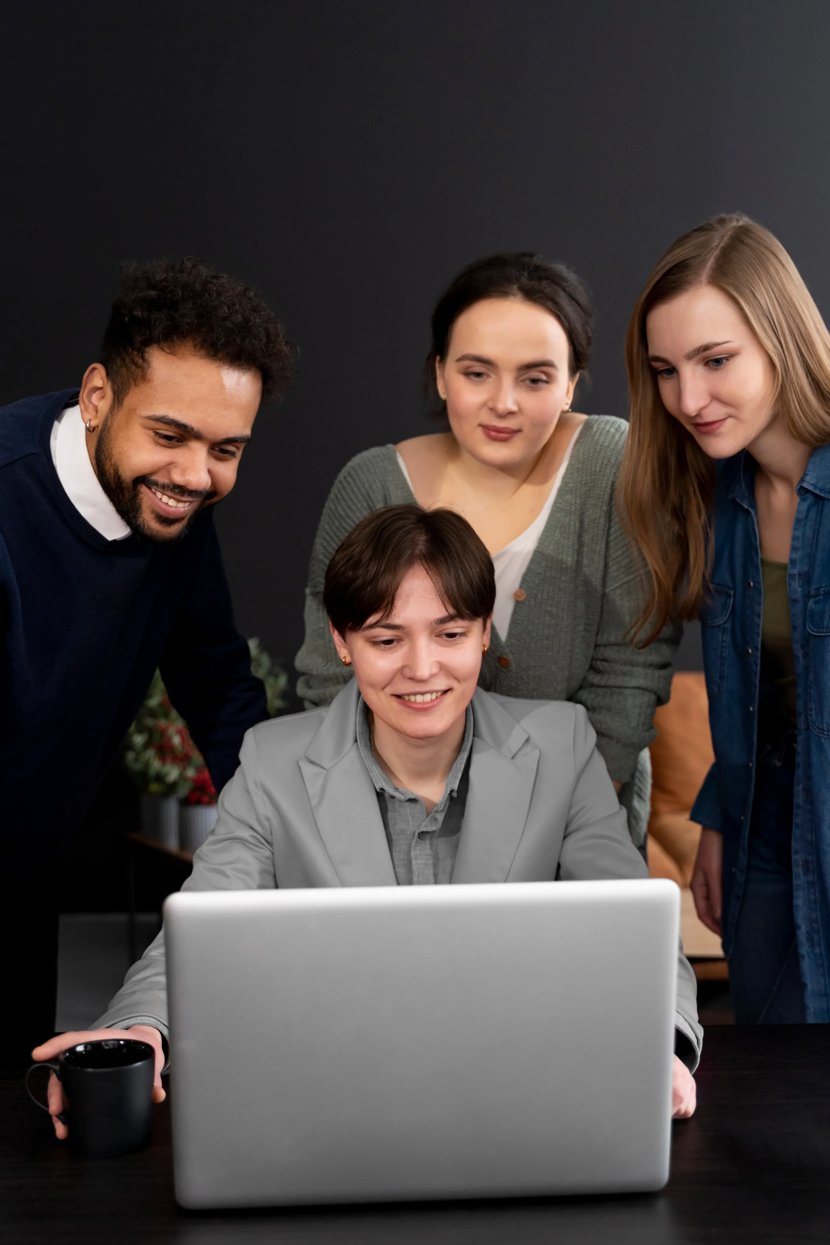 A small team of entrepreneurs gathered around a computer