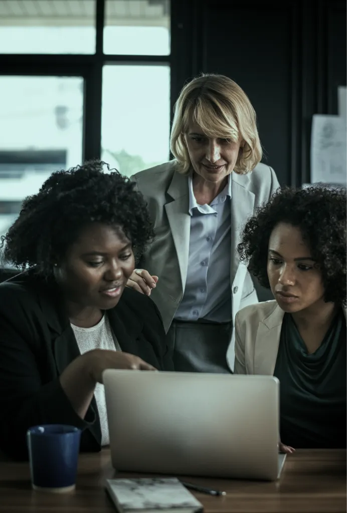 Women working together around a laptop